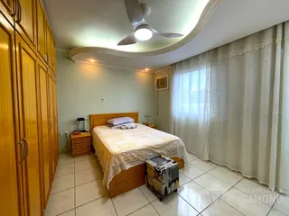 Quarto com cama de madeira e armários em uma residência.
