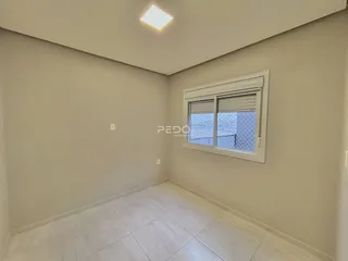 Vista interna de uma sala com paredes claras e piso de cerâmica.