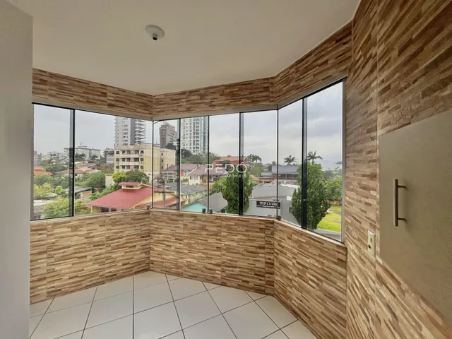Sala de estar com grandes janelas que oferecem uma vista da paisagem urbana.
