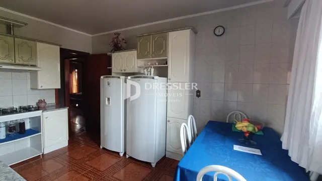 Foto de uma cozinha com armários brancos e piso de madeira.