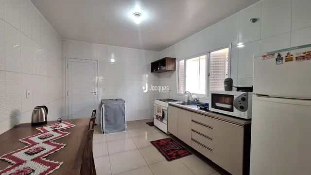 Interior de uma sala com cozinha e piso de cerâmica em Lajeado.