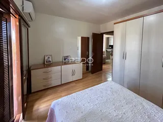 Quarto com armários e piso de madeira em imóvel no Brasil.