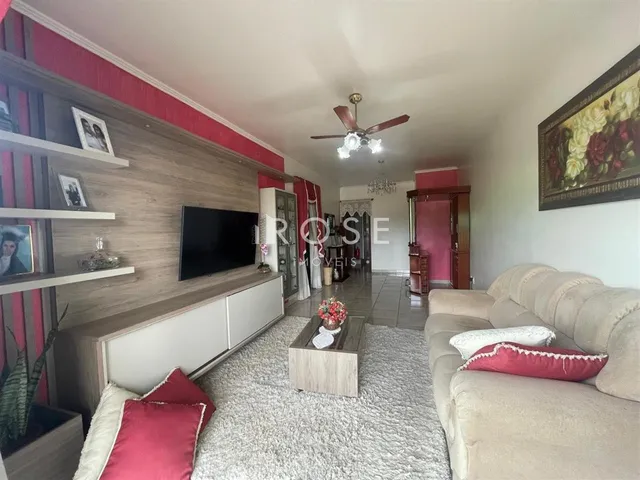 Sala de estar com sofá e painel decorativo em um imóvel no Brasil.