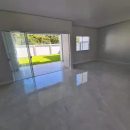 Sala de estar com porta de vidro que dá acesso a um pátio externo.