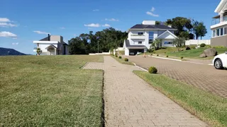 Fachada de uma casa moderna com jardim gramado em Lajeado.