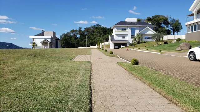 Fachada de uma casa moderna com jardim gramado em Lajeado.