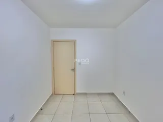 Corredor interno com paredes brancas e piso de cerâmica.