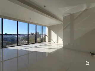 Sala de estar ampla com grandes janelas de vidro.