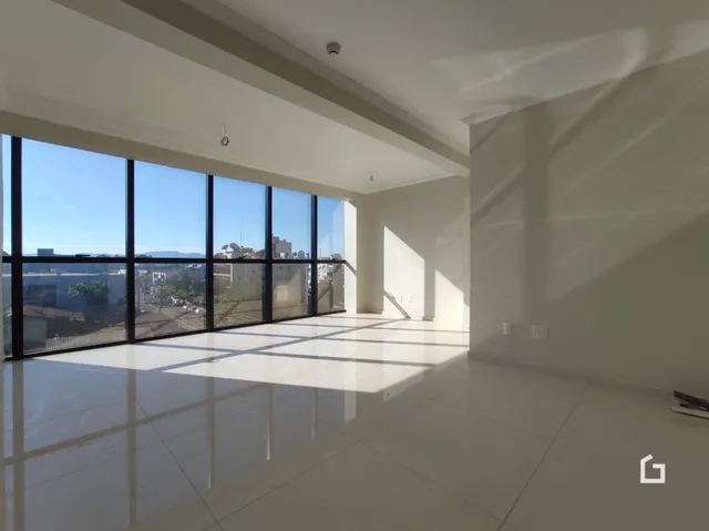 Sala de estar ampla com grandes janelas de vidro.
