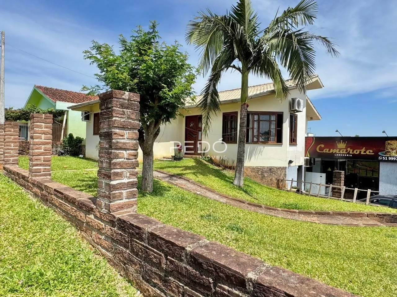 Fachada de uma residência com jardim e cerca em Lajeado, Brasil.