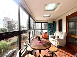Sala de estar com grandes janelas que oferecem uma vista da cidade.