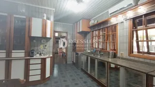 Interior da cozinha com armários e revestimentos brancos e marrons.