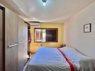 Quarto com cama de casal e janela de madeira no imóvel.
