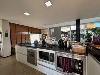 Cozinha moderna com bancada escura e grandes janelas.