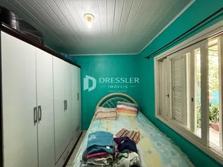 Quarto com armários brancos e parede verde-água em imóvel no Brasil.