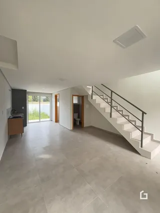 Vista interna de um espaço com piso de cerâmica e escadaria.
