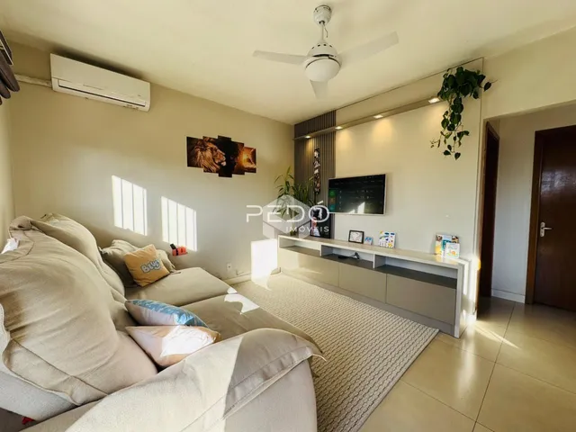 Sala de estar com um sofá grande e luz natural.