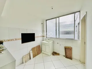 Sala de estar com piso branco e grande janela na residência.