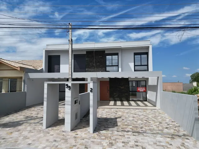 Fachada de uma casa moderna com paredes brancas e piso de pedra em Lajeado, Brasil.