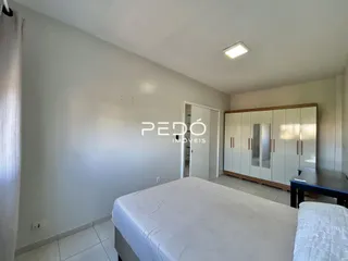 Quarto com cama e guarda-roupa branco.