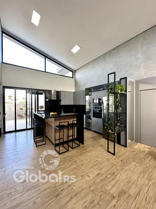 Interior de uma sala de estar com piso de madeira e cozinha moderna.