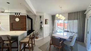 Uma sala de jantar moderna com mesa de vidro e cadeiras em um apartamento.
