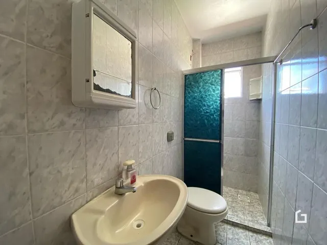 Foto de um banheiro com azulejos brancos e louças sanitárias.