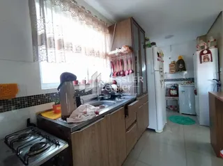 Cozinha com armários de madeira e janela na residência.