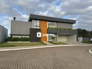Fachada moderna de uma residência em Lajeado, Brasil, com detalhes em madeira e revestimento cinza.