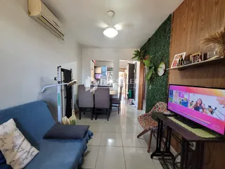 Sala de estar com sofá azul e parede de madeira no imóvel.