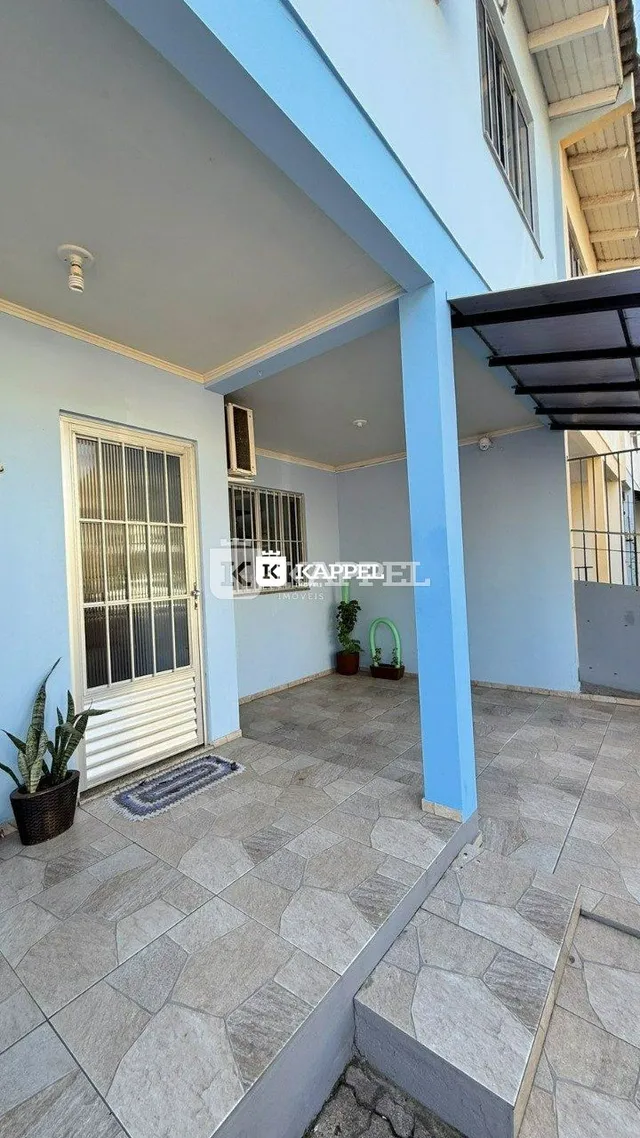 Foto de uma área externa coberta com piso de cerâmica e coluna azul.
