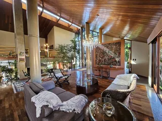 Sala de estar com pé direito alto e vigas de madeira em Lajeado, Brasil.
