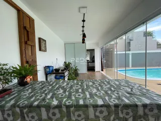 Quarto com cama grande e porta de madeira em uma residência.