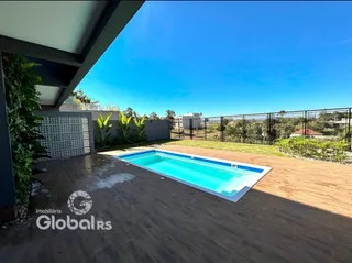 Foto da piscina e área externa com vista para a paisagem.