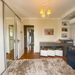 Sala de estar com piso de madeira e espelho.
