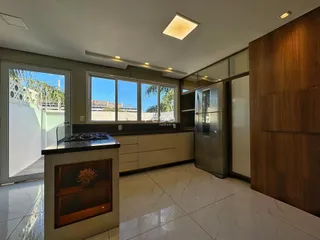 Cozinha moderna com armários e piso de mármore claro.