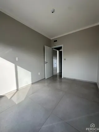 Hall de entrada com piso de porcelanato cinza e paredes brancas.