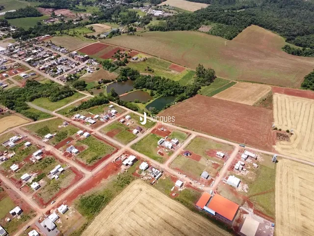 Vista aérea de uma propriedade rural com campos e áreas de vegetação.