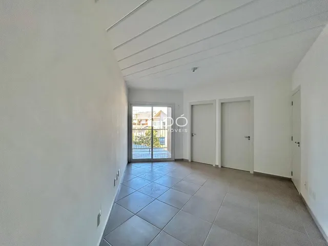 Hall de entrada com paredes brancas e piso de cerâmica.