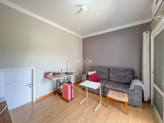 Foto da sala de estar com sofá e piso de madeira em um imóvel.