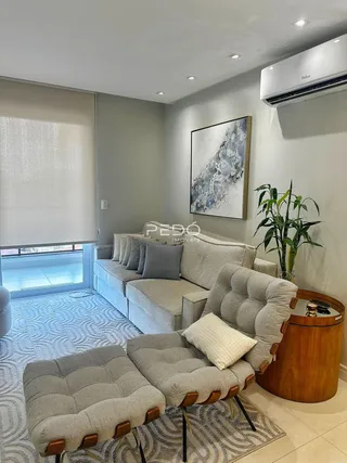 Sala de estar com sofá e poltronas em ambiente interno.
