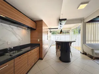 Interior de uma sala de estar com cozinha e área de jantar em um imóvel.