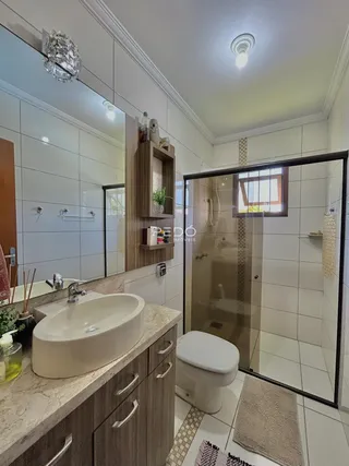 Banheiro com revestimento cerâmico e bancada de granito.