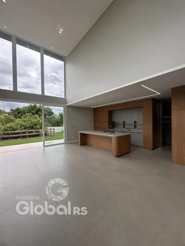 Ambiente interno de uma sala ampla com grandes janelas.