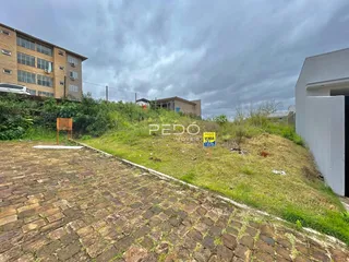 Vista externa de um terreno com pavimentação e vegetação.