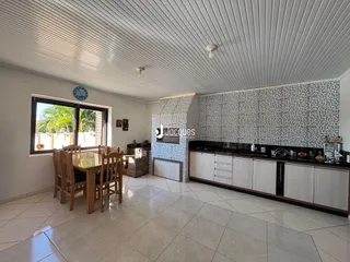 Ambiente interno de uma sala de jantar com vista para o exterior.