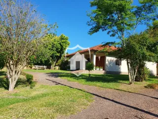 A fachada de uma casa em Lajeado, Brasil, cercada por gramado e árvores.