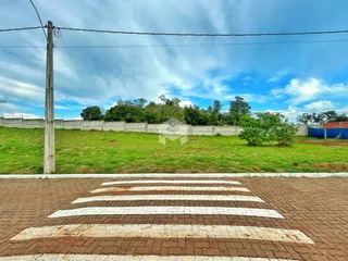 Vista da propriedade com um campo gramado e cerca ao fundo.