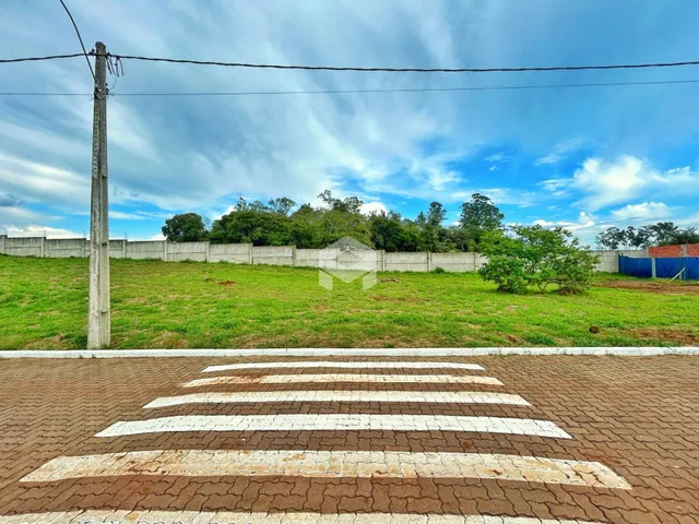 Vista da propriedade com um campo gramado e cerca ao fundo.