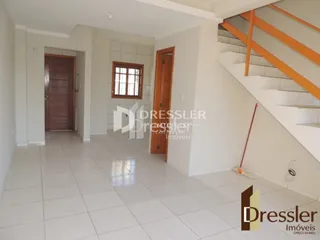 Hall de entrada com piso de cerâmica e escadaria.